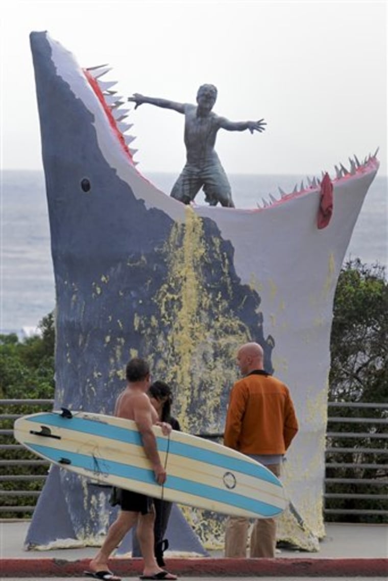 Surfers examine the "Magic Carpet Ride" sculpture in Cardiff-by-the-Sea, Calif.